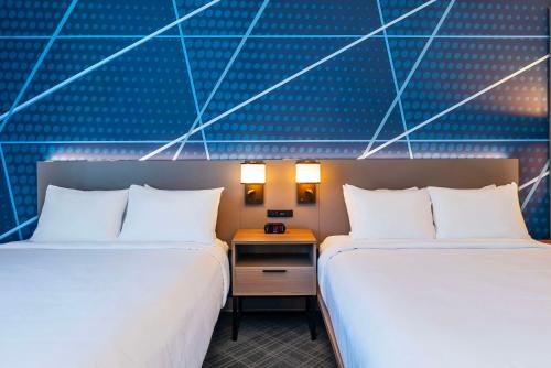 two beds sitting next to each other in a room at Comfort Suites Kelowna in Kelowna