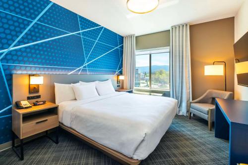 a hotel room with a large bed and a desk at Comfort Suites Kelowna in Kelowna