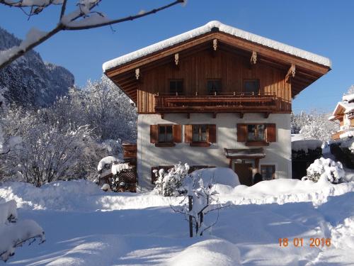 un edificio ricoperto di neve con alberi innevati di Haus Binderschuster a Unken