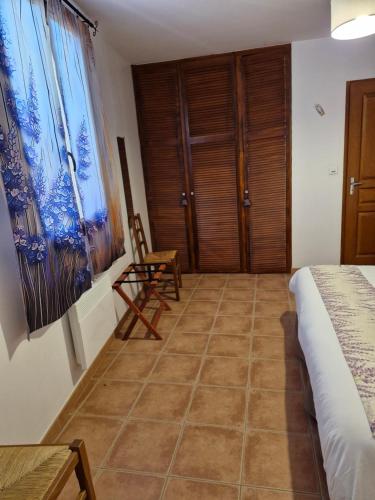 a bedroom with a bed and a table and a chair at Chambres d'hôtes à Pêtre in Entrevennes