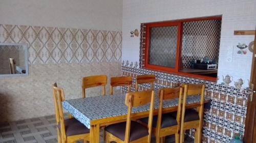 a dining room with a wooden table and chairs at La Belle Appartement - Sipres 5, plage in Mbaw