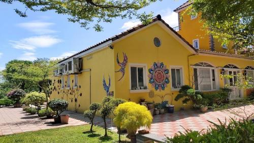 a yellow house with flowers painted on it at Peas Country House in Wanluan