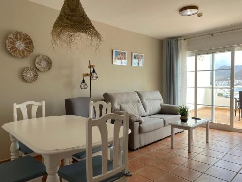 a living room with a table and a couch at Apartahotel Vistamar San José in San José