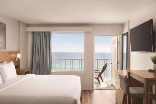 a hotel room with a bed and a view of the ocean at Radisson Beachfront Hotel - Panama City Beach in Panama City Beach