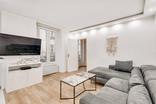 un salon avec un canapé et une télévision à écran plat dans l'établissement Appart 4pers#Malesherbes#Parc Monceau, à Paris