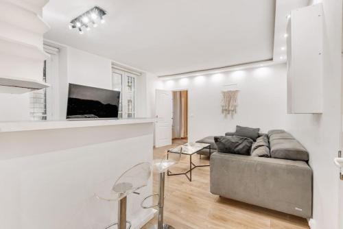 un salon blanc avec un canapé et une table dans l'établissement Appart 4pers#Malesherbes#Parc Monceau, à Paris