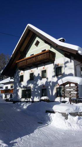a snow covered building with a sign in front of it at Gästehaus Hosp in Reutte