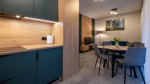 Una cocina y un comedor con mesa y sillas. en Ostoja Beskidy, Sun & Snow, en Szczyrk