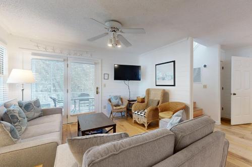 a living room with a couch and a tv at Pelican Bay 46 in Isle of Palms
