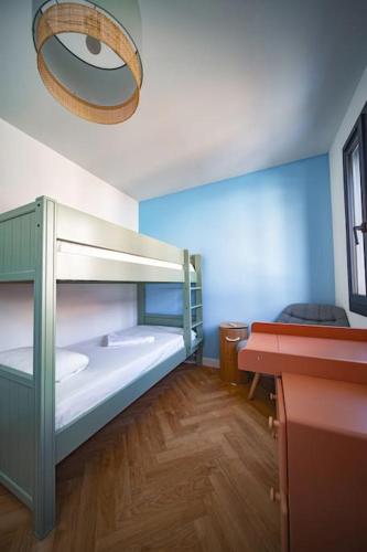 une chambre avec deux lits superposés et un bureau dans l'établissement La maison du soleil à 2 pas de la plage, à Canet