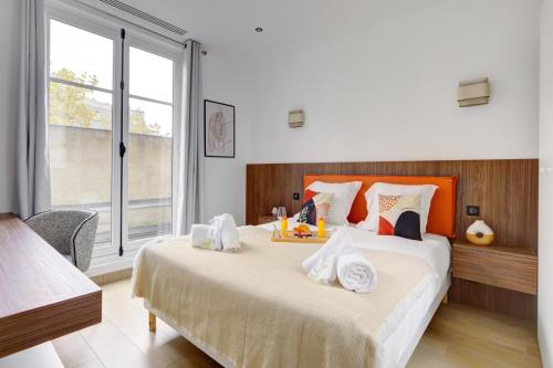 une chambre avec un grand lit avec des serviettes dessus dans l'établissement Bluestay 294 - Superbe appartement à Paris 17, à Paris