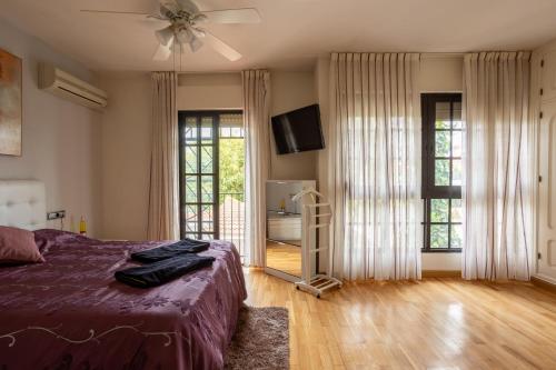 ein Schlafzimmer mit einem Bett und einem Deckenventilator in der Unterkunft Casa en Guadalmar Malaga, Naturaleza y Playa in Málaga