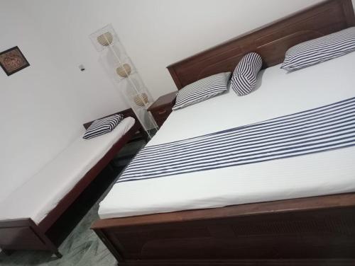 two beds with black and white striped pillows at Blue Moon Villa in Waskaduwa