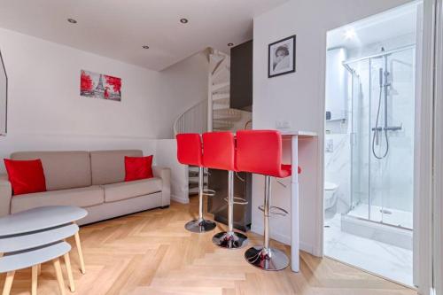 un salon avec un canapé et des chaises rouges dans l'établissement MyKeypers - Stylish & Luxury Duplex 2BR-8P - Le Marais, à Paris