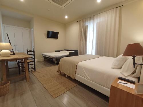 a hotel room with a bed and a table and a desk at Uma Suites Parada del Marqués in Seville