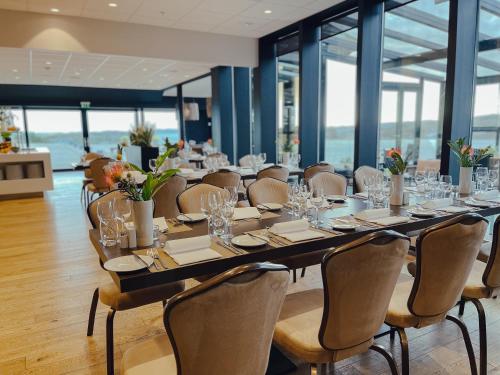 a long dining room with a long table and chairs at Panorama Hotell & Resort in Steinsland