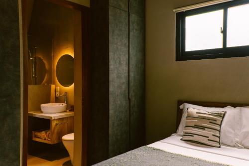 a bedroom with a bed and a sink and a window at Twinseas Villa in Uluwatu
