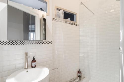 une salle de bain blanche avec un lavabo et une douche dans l'établissement Le Milady - Charmant appartement au cœur de Rennes, à Rennes