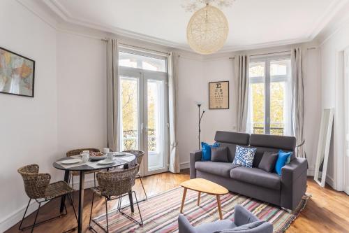 un salon avec un canapé et une table dans l'établissement Le Milady - Charmant appartement au cœur de Rennes, à Rennes