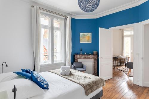 une chambre bleue avec un lit et une cheminée dans l'établissement Le Milady - Charmant appartement au cœur de Rennes, à Rennes