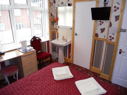 een badkamer met een wastafel en een bureau en een wastafel bij The Gordon in Scarborough