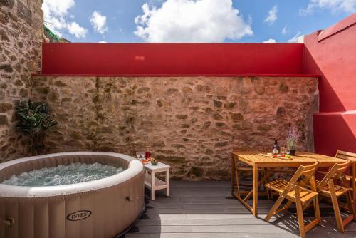 a hot tub on a patio with a table and chairs at Host Wise - Modern Comfy Flat in Porto