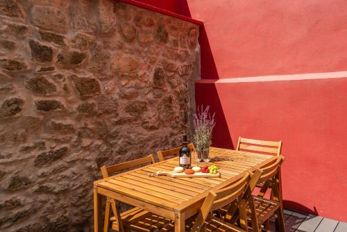 a wooden table with fruit on it next to a wall at Host Wise - Modern Comfy Flat in Porto