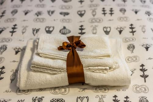 uma pilha de toalhas com um laço numa cama em Buon Vento em Matera
