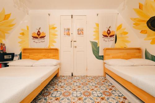 two beds in a room with flowers on the walls at Playa las Flores in Zambales