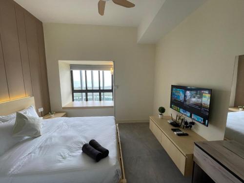 a bedroom with a large bed and a flat screen tv at Imperio Residence with Private Bathtub by Lets Stay in Malacca