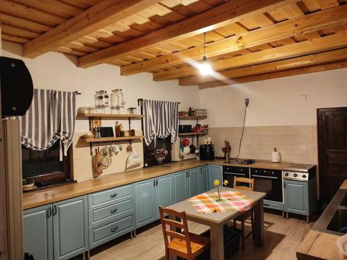 a kitchen with blue cabinets and a table in it at RéBa Old Barn in Estelnic