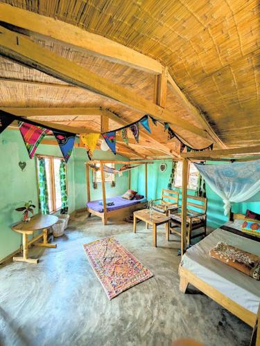 a room with a room with a bed and tables at Butterfly Space- A Non-Profit Eco-Lodge in Nkhata Bay