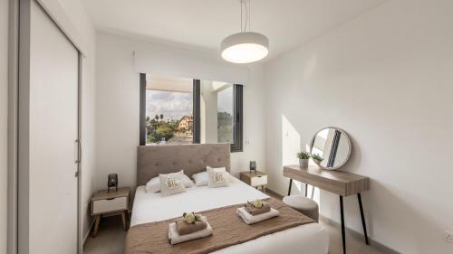 a white bedroom with a bed and a mirror at Nissi Residences Villa 4 in Ayia Napa