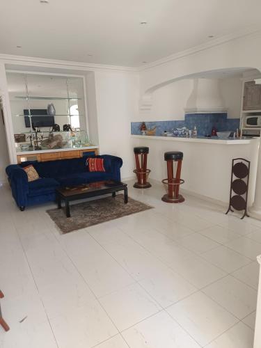 un salon avec un canapé bleu et une table dans l'établissement La matoune, à Cannes