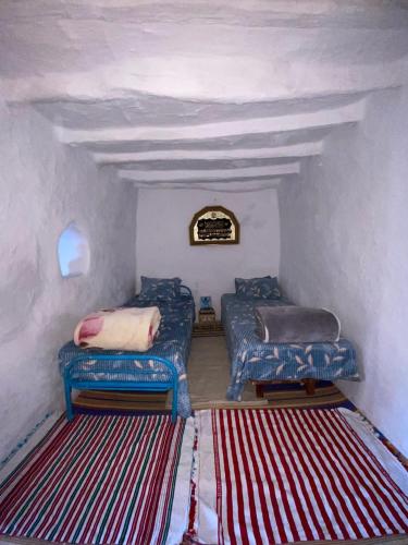 a room with two blue couches and a rug at The Endless Enigma in Tazroutane