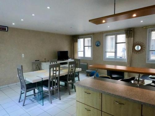 une cuisine et une salle à manger avec une table et des chaises dans l'établissement Appartement sur le port de Saint-Vaast-la-Hougue, à Saint-Vaast-la-Hougue