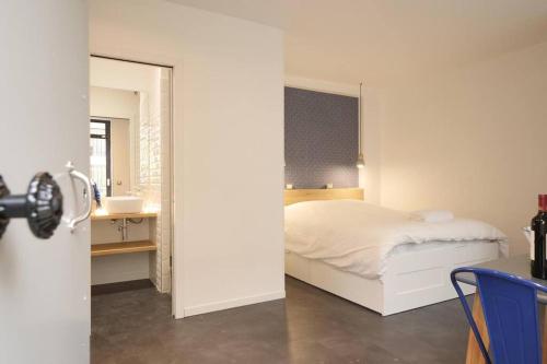 - une chambre avec un lit blanc et un lavabo dans l'établissement MyKeypers - Cozy Studio near Canal Saint Martin, à Paris