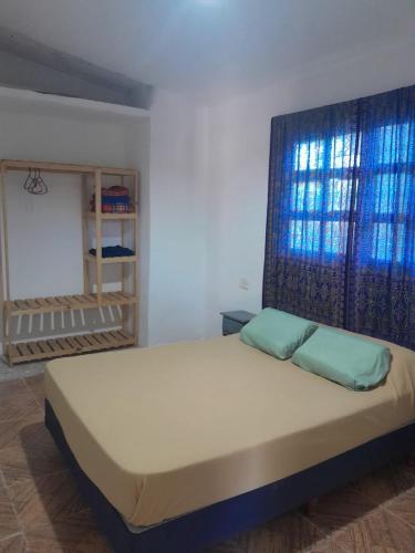 a bedroom with a bed with a large window at Casa Azul in Villa del Dique