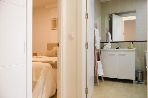 Un dormitorio pequeño con una cama y un espejo. en TAYP San Marcos 102, en Talayuela