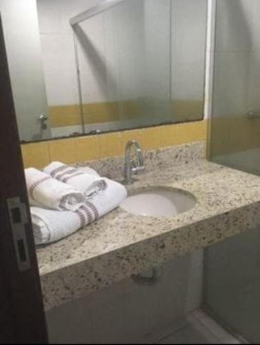 a bathroom counter with a sink and a mirror at PIPAs BAY APARTHOTEL in Pipa