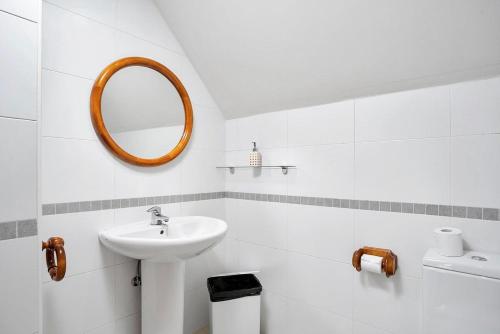 a white bathroom with a sink and a mirror at Argualas - Triplex con piscina - By CARDI Suites in Panticosa