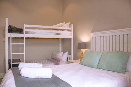 a bedroom with two bunk beds in a room at Luxury Beach House in Romansbaai Estate in Gansbaai