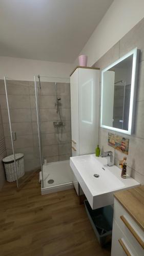 a bathroom with a white sink and a shower at Családbarát lakás Szombathely szívében in Szombathely