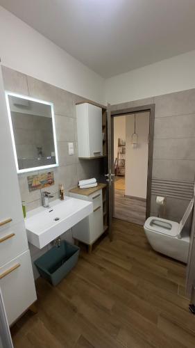 a bathroom with a white sink and a toilet at Családbarát lakás Szombathely szívében in Szombathely