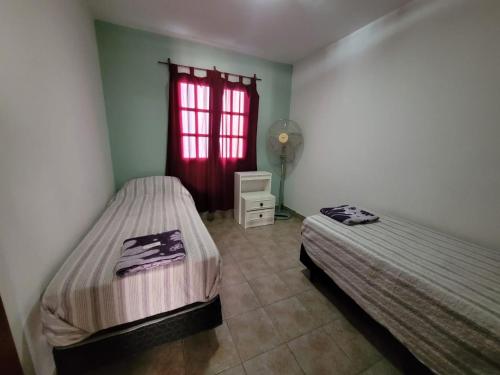 a bedroom with two beds and a red window at Malepa in Salta