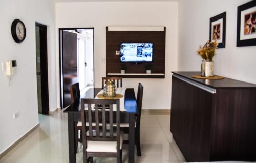 ein Esszimmer mit Tisch und Stühlen und einem Fernseher in der Unterkunft Villa María Urban Aparts in Villa María