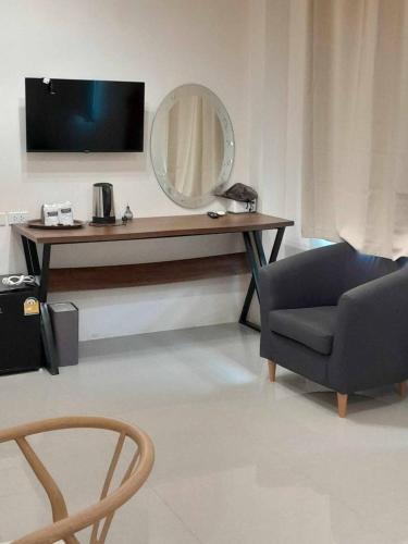a living room with a table with a mirror and a chair at ขุนโลหะ in Phuket Town
