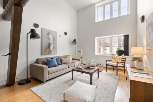 a living room with a couch and a table at Charming Loft, High Ceiling !Modern & Central, Free private Parking 7 min walking ! in Trondheim