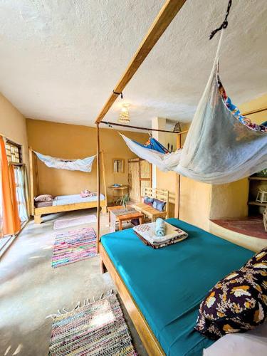 a room with a bed with a hammock in it at Butterfly Space- A Non-Profit Eco-Lodge in Nkhata Bay