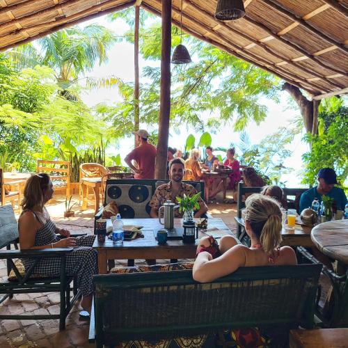 a group of people sitting at a table at a restaurant at Butterfly Space- A Non-Profit Eco-Lodge in Nkhata Bay